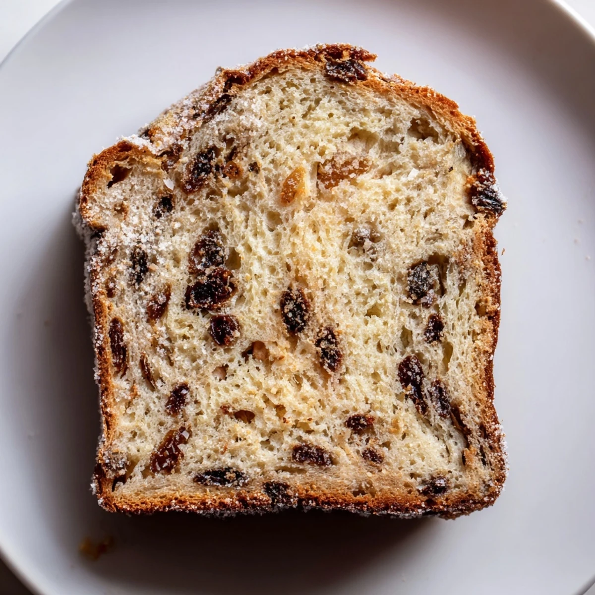 A golden, baked Old-Fashioned German Raisin Bread loaf, ready to be sliced, perfect for breakfast.