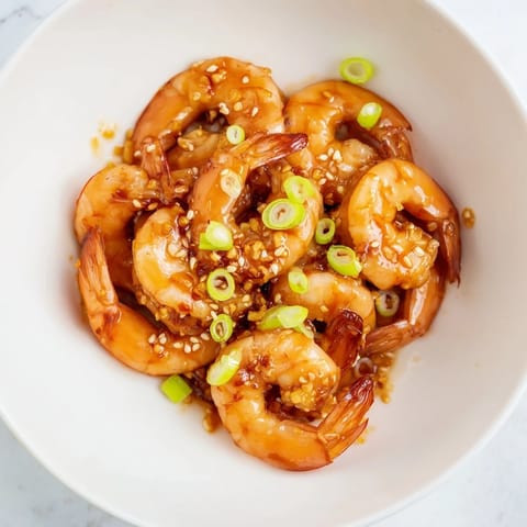 Close-up of golden-brown Honey Garlic Shrimp, served over fluffy white rice, delicious.