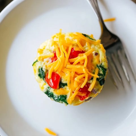 Freshly baked veggie egg muffins with cheese and vibrant vegetables, perfect for meal prep.