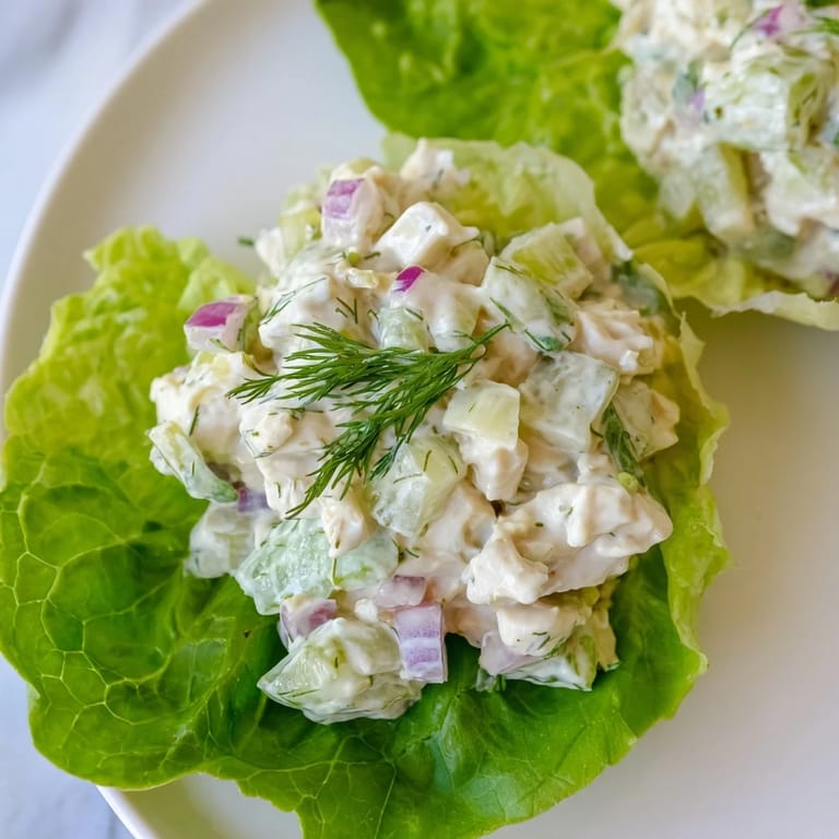 A top view of Dill Pickle Chicken Salad Lettuce Cups garnished with fresh dill and chopped pickles, ideal for a low-carb lunch.  