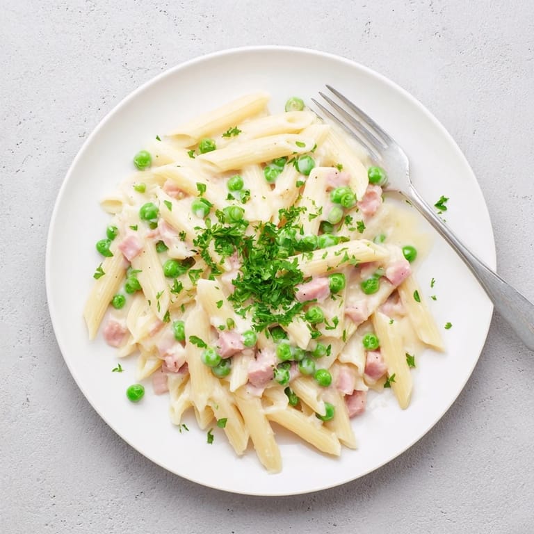 Dampfende Penne mit süßen Erbsen, saftigem Schinken und cremiger Sauce – ein herzhaftes, schnelles Frühlingsgericht.